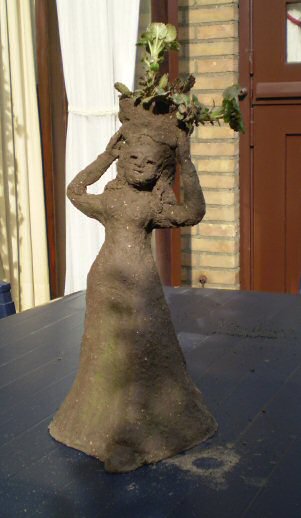 Roodgebakken klei - vrouw met plantenbak op hoofd